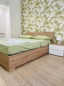 1 cama con marco de madera en un dormitorio en La Casa di Nonna Cristina, en Castellammare di Stabia