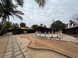 um caminho na terra em frente a alguns edifícios em A 1 minuto do Mar! Casa Mármore V4 em Zona Sossegada na Ilha do Mussulo em Belas