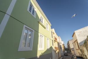 un edificio verde y amarillo en una calle en Best Houses 56 - Charming House in Peniche, en Peniche