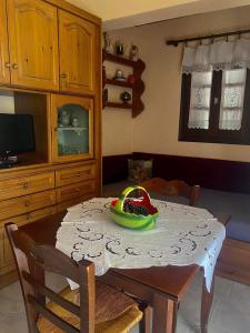 una cocina con una mesa con un bol de fruta. en Διαμέρισμα Αγγελική, en Makrinitsa