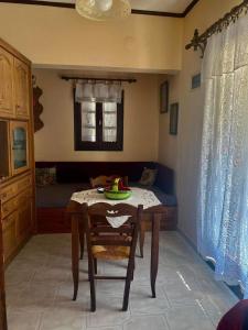 un comedor con una mesa con un bol de fruta. en Διαμέρισμα Αγγελική, en Makrinitsa