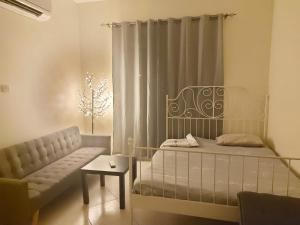 1 dormitorio con cama, sofá y ventana en Nice studio for stay .. en Al Ain