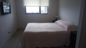 Tempat tidur dalam kamar di Depto. con vista al mar 4° piso, Tomé, Dichato