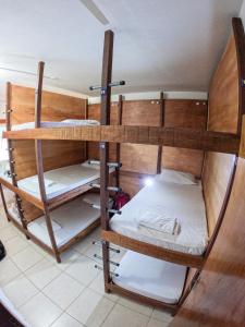 a room with three bunk beds in a room at The Beach Hostel Milagres in São Miguel dos Milagres