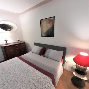 een slaapkamer met een bed en een rode lamp bij Suite Vittoria in Napels