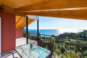 a balcony with a table and chairs and the ocean at Luxury Loft Apartment with Pool - Pelekas Beach, Corfu in Pelekas +19 photos
