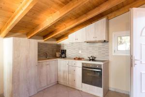a kitchen with wooden ceilings and a sink and a stove at Luxury Loft Apartment with Pool - Pelekas Beach, Corfu in Pelekas