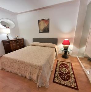 een slaapkamer met een bed en een tafel met een lamp bij Suite Vittoria in Napels