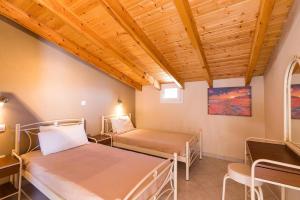 2 łóżka w pokoju z drewnianym sufitem w obiekcie Luxury Loft Apartment with Pool - Pelekas Beach, Corfu w mieście Pelekas