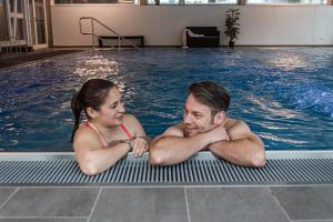 a man and a woman in a swimming pool at Wellness- & Sporthotel Haus am See in Arendsee