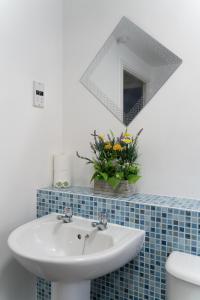 ein Bad mit einem Waschbecken und einem Spiegel in der Unterkunft 3 Smart TVs, Sleeps 3, VAN PARKING, Fast WIFI in Corby