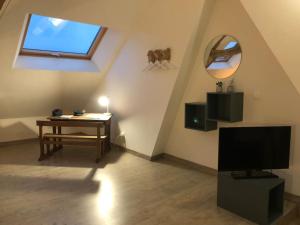 Televízia a/alebo spoločenská miestnosť v ubytovaní Maison sur la place du village d’Ourville en Caux