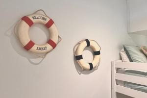 dos salvavidas están colgando en una pared blanca en Stay and Sea!, en Sídney