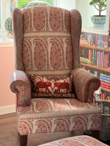 a chair with a pillow in a living room at Cosy country cottage in rural location in Moffat