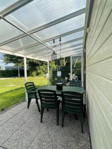 a patio with a table and chairs under awning at Chalet D12 - Camping it Soal in Workum