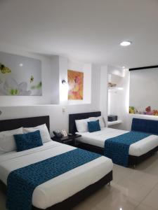 duas camas num quarto com azul e branco em hgo hotel em Cali
