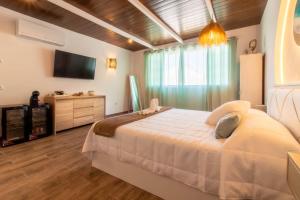 Room in Guest room - Private room in the fishing port of Marbella في مربلة: غرفة نوم بسرير كبير وتلفزيون