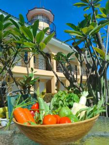 a bowl of vegetables on a table in front of a building at Villa Del Faro in Batangas City