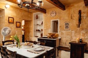 瓦莱塔Enchanting 2BDR Townhouse in Valletta Centre!的一间带桌子的餐厅和一间厨房 更多34张照片