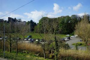 a parking lot with cars parked in a field at Rhos Cottage in Conwy