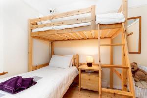 a bedroom with a bunk bed with a ladder at Rhos Cottage in Conwy