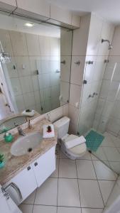 a bathroom with a sink and a toilet and a mirror at Marina Bezerril - Cobertura Lemon Flat - A melhor de Ponta Negra in Natal