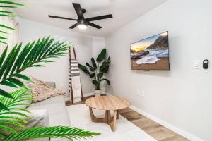 a living room with a couch and a ceiling fan at Hawaii Dream Escape! Steps from the Sand in Hauula