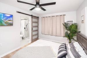 a white living room with a ceiling fan at Hawaii Dream Escape! Steps from the Sand in Hauula