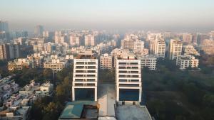 a tall white building in front of a city at Ramee International Surat in Surat