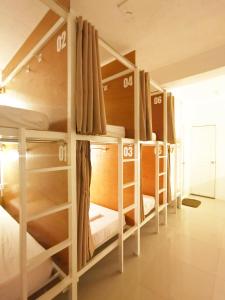 un gruppo di letti a castello in una stanza di NomadsMNL Airport Hostel a Manila