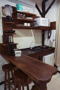 a kitchen with a wooden table with stools at Sítio Urbano a apenas 1,5 km do centro in Blumenau