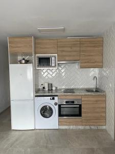 a kitchen with a white refrigerator and a microwave at HUELIN PLAYA in Málaga