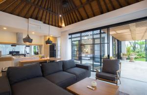 uma sala de estar com um sofá e uma mesa em The Kon's Villa Bali Seminyak em Seminyak