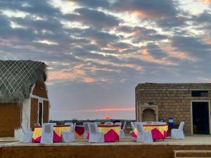 a group of white chairs and tables on a patio at Golden villa in Jaisalmer