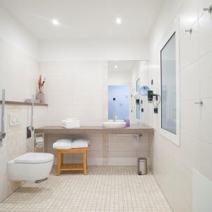 a white bathroom with a toilet and a sink at Gasthaus Rech in Eppelborn