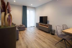 a living room with a television and a table and chairs at Gasthaus Rech in Eppelborn