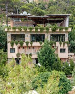 a building with plants on the side of it at Blue Jay Valley in Jezzîne