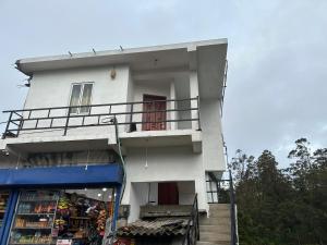 a white building with a store in front of it at Sushi guest - mini in Nuwara Eliya