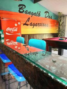 ein Coca-Cola-Tagesrestaurant mit einem Tisch und Stühlen in der Unterkunft Bangalô das Lagartixas ,casa stúdio com piscina aquecida privativa a 20 minutos do Centro de Curitiba in Colombo