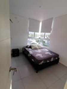 a bedroom with a bed in a room with a window at Apartamento en Santa Marta, Rodadero Jacuzzi y Sauna in Gaira