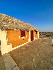 a small building with a thatched roof on the beach at Golden villa in Jaisalmer