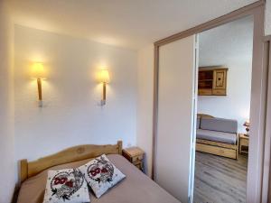 a small bedroom with a bed and a mirror at Appartement Les Menuires, 2 pièces, 4 personnes - FR-1-178-133 in Les Menuires