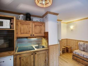 une cuisine avec des armoires en bois et un évier dans l'établissement Joli Studio 2 Pers, Wifi, Animaux Admis, Parking - FR-1-178-180, aux Menuires