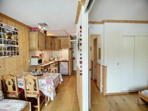 里蒙紐耶的住宿－Appartement Les Menuires, 2 pièces, 4 personnes - FR-1-178-181，厨房配有木制橱柜和带盒子的桌子。