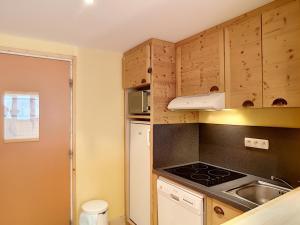 uma pequena cozinha com um fogão e um lavatório em Appartement Les Menuires, 2 pièces, 5 personnes - FR-1-178-291 em Les Menuires