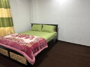 a small bedroom with a bed with green sheets at Sushi guest - mini in Nuwara Eliya