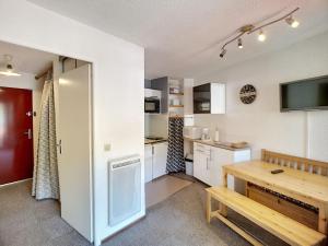 eine Küche mit weißen Schränken und einem Holztisch in der Unterkunft Studio Les Menuires, 1 pièce, 4 personnes - FR-1-178-150 in Les Menuires