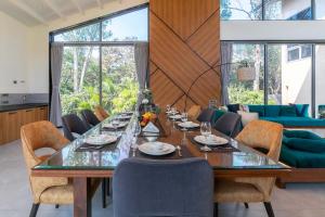 une salle à manger avec une grande table et des chaises dans l'établissement The Den by StayVista - Private pool with Deck & Jacuzzi, Manicured gardens with Gazebos, Projector, Turf & Terrace, à Karjat