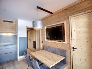 a room with a wooden wall with a table and a tv at Appartement Les Menuires, 2 pièces, 4 personnes - FR-1-178-309 in Les Menuires