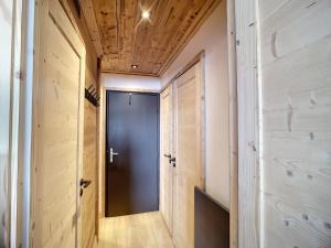 um corredor com uma porta azul e paredes de madeira em Appartement Les Menuires, 2 pièces, 4 personnes - FR-1-178-309 em Les Menuires